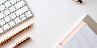 pen near black lined paper and eyeglasses